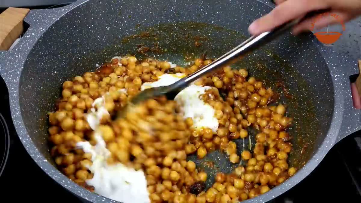 Mixing chickpeas and yogurt into the masala